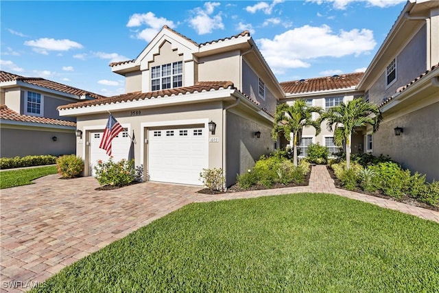 mediterranean / spanish home featuring a front yard and a garage