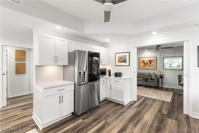 kitchen with appliances with stainless steel finishes, light countertops, ceiling fan, and white cabinetry