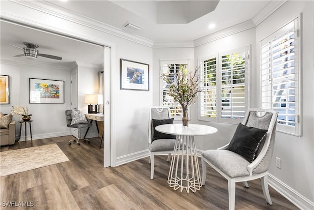 dining room with visible vents, baseboards, ceiling fan, wood finished floors, and crown molding