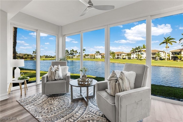 sunroom featuring a water view and ceiling fan