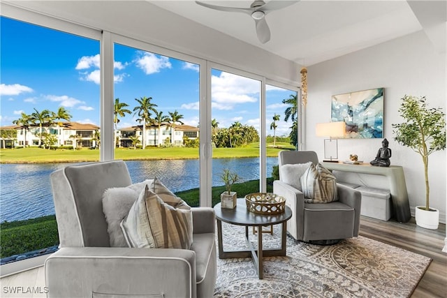 sunroom / solarium with a water view and a ceiling fan