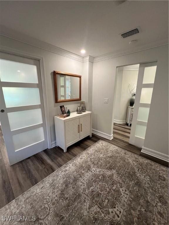 bathroom with visible vents, crown molding, vanity, and wood finished floors