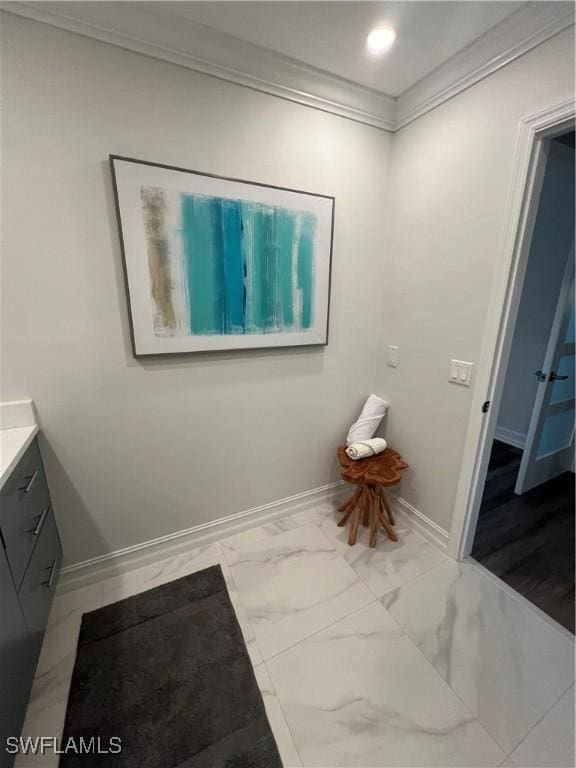 bathroom featuring marble finish floor, baseboards, ornamental molding, and vanity