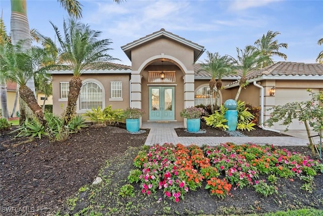 view of exterior entry featuring a garage and french doors