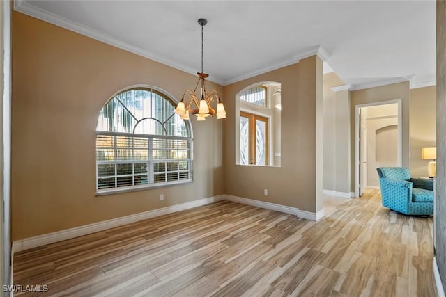 unfurnished dining area featuring crown molding, light hardwood / wood-style floors, and a notable chandelier