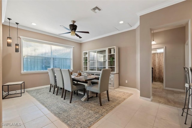 tiled dining room with ceiling fan and ornamental molding