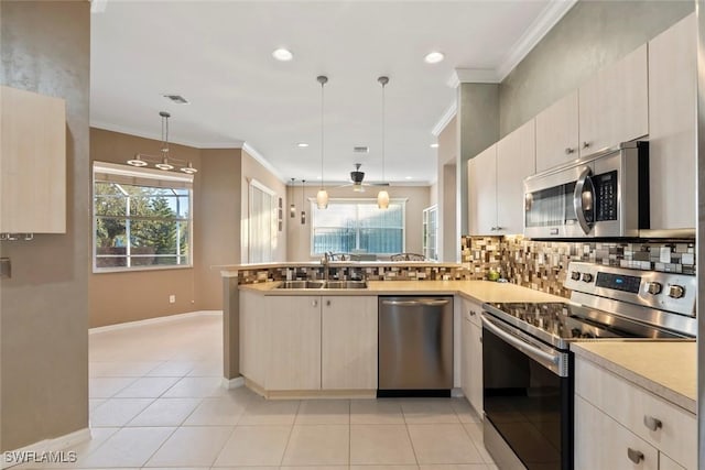 kitchen featuring sink, hanging light fixtures, light tile patterned floors, kitchen peninsula, and stainless steel appliances