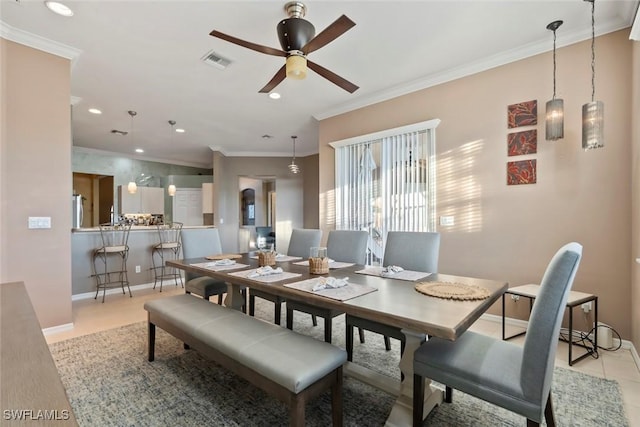 tiled dining room with crown molding and ceiling fan