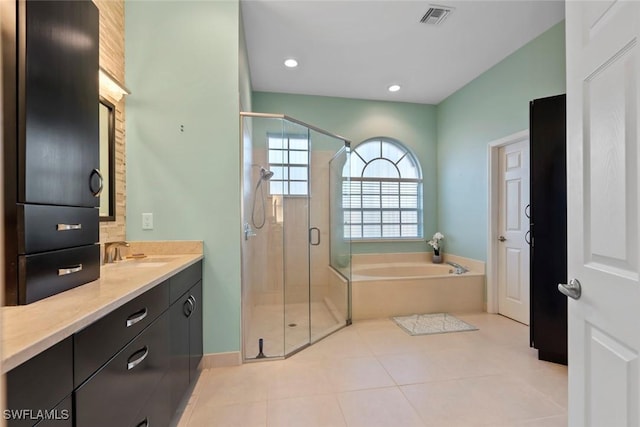 bathroom featuring tile patterned flooring, vanity, and plus walk in shower