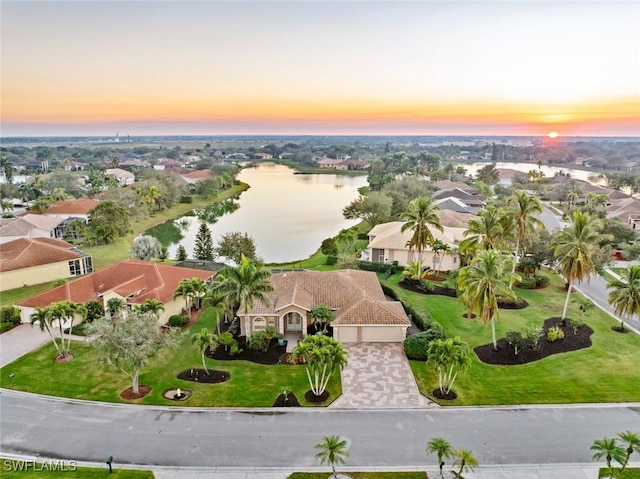 aerial view at dusk featuring a water view