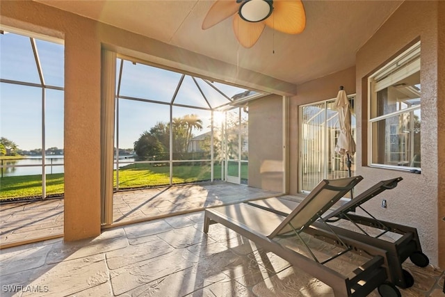 sunroom with a water view and ceiling fan