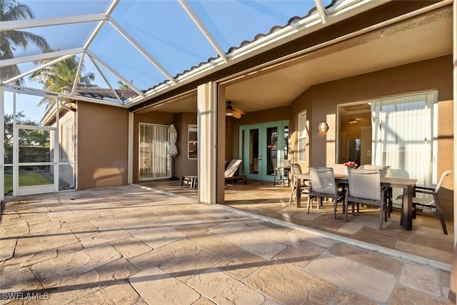 rear view of property featuring a lanai, a patio area, ceiling fan, and french doors