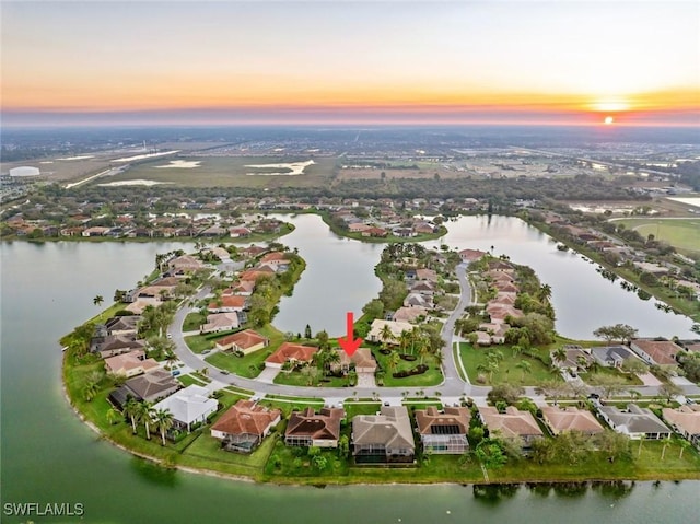 aerial view at dusk featuring a water view