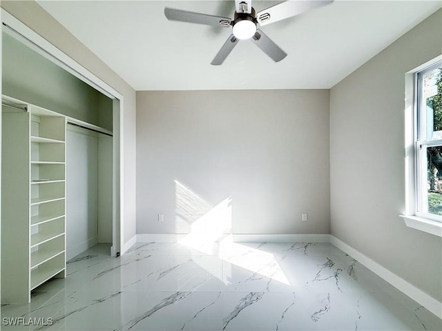 unfurnished bedroom with ceiling fan, a closet, and multiple windows