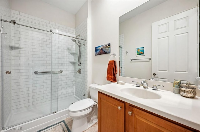 bathroom with vanity, a shower with shower door, and toilet