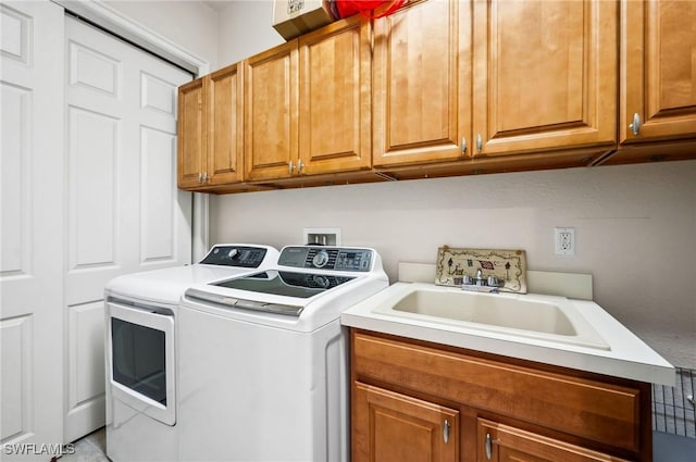 laundry room featuring cabinets, sink, and washer and dryer