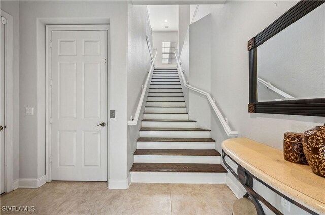 stairs featuring baseboards and tile patterned flooring