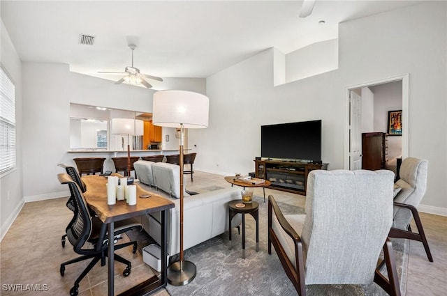 living room with baseboards, ceiling fan, vaulted ceiling, and visible vents