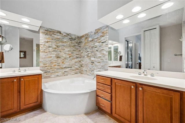 bathroom featuring tile patterned flooring, vanity, and a washtub