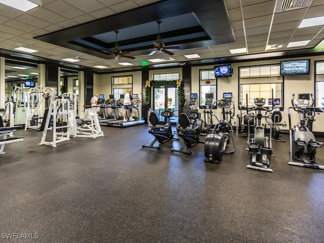 gym with a paneled ceiling and ceiling fan