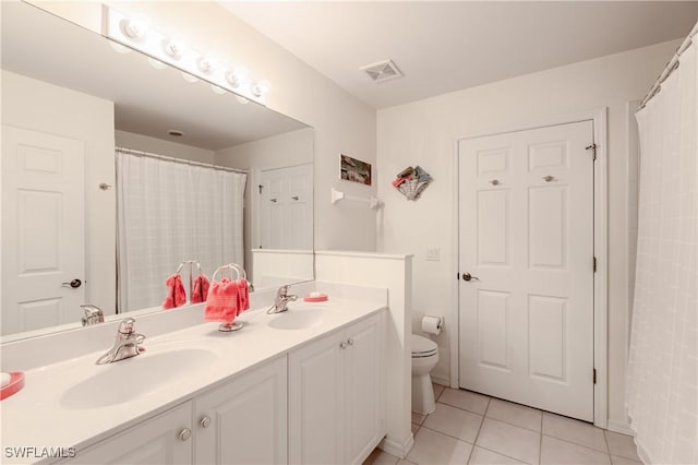 bathroom featuring tile patterned flooring, vanity, and toilet