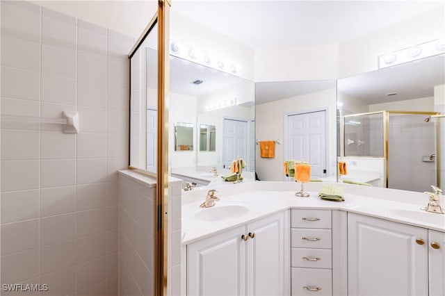 bathroom with vanity and a shower with door