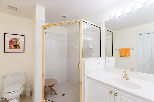 bathroom featuring tile patterned flooring, vanity, toilet, and walk in shower