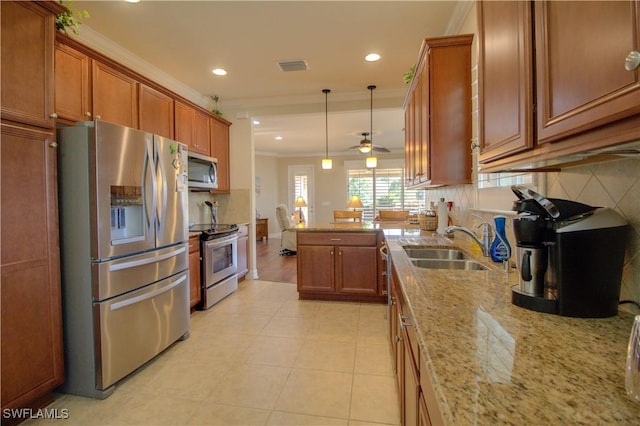 kitchen with light stone countertops, stainless steel appliances, ceiling fan, and crown molding