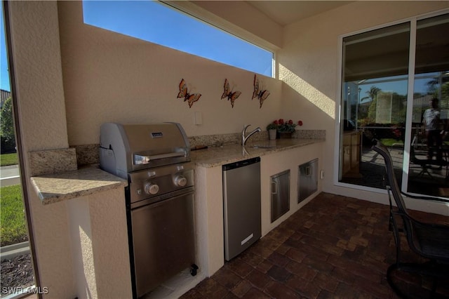 view of patio / terrace with an outdoor kitchen, area for grilling, and sink