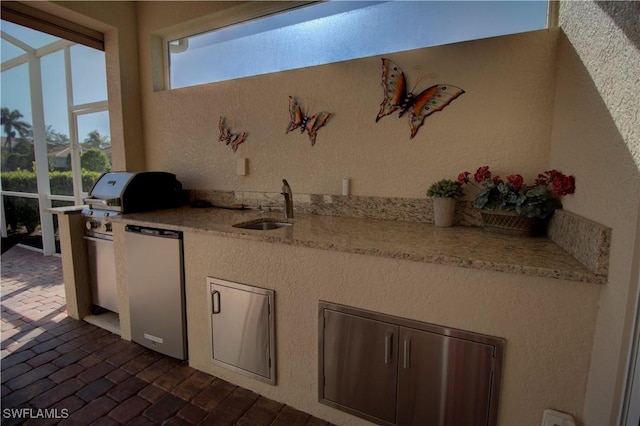 interior space with light stone counters, sink, and refrigerator