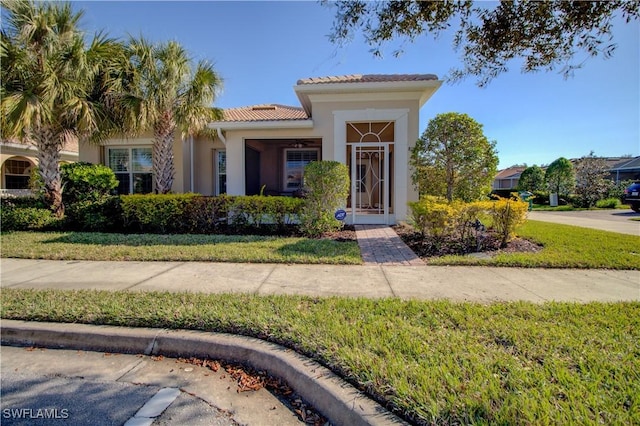 mediterranean / spanish-style home with a front lawn