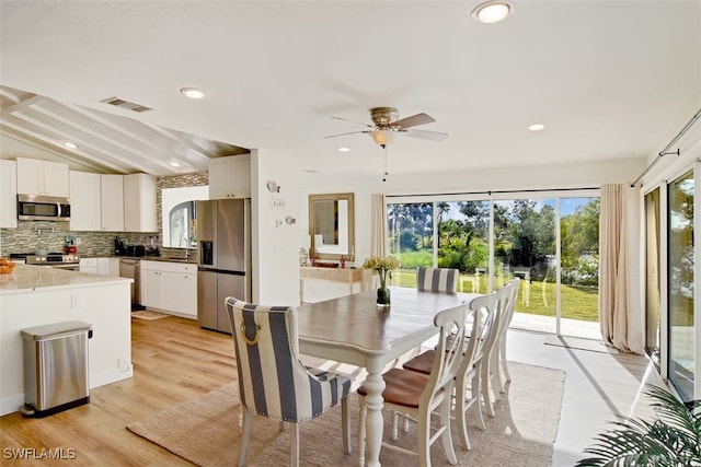 dining room featuring ceiling fan, light wood-type flooring, and lofted ceiling