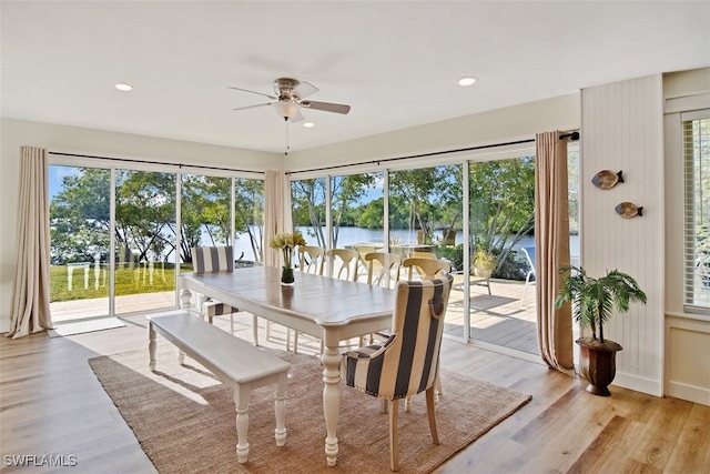 sunroom featuring ceiling fan and a water view