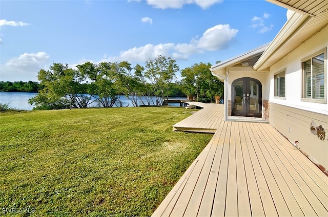 view of yard with french doors and a water view