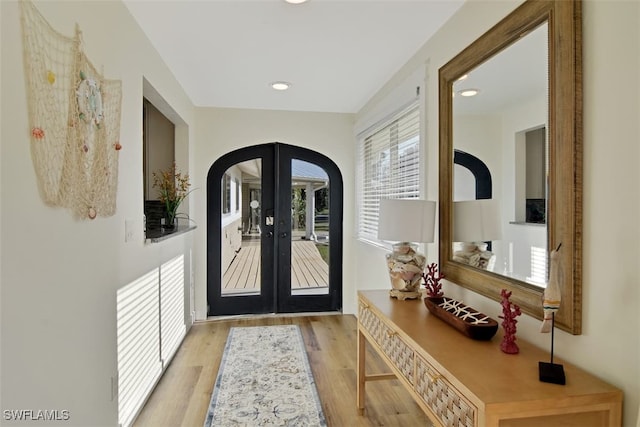 doorway with french doors and light hardwood / wood-style flooring