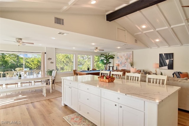 kitchen featuring white cabinetry, a center island, pool table, light hardwood / wood-style floors, and light stone countertops