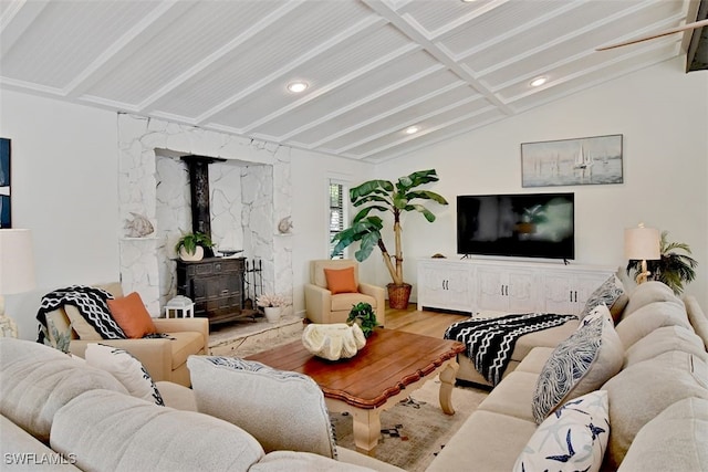 living room featuring lofted ceiling, a wood stove, and hardwood / wood-style flooring