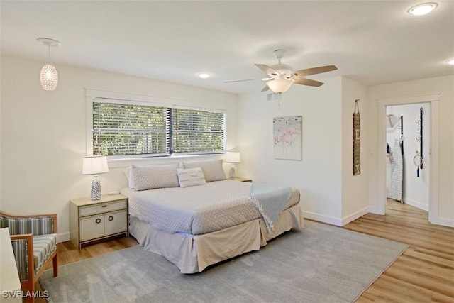 bedroom with ceiling fan and light hardwood / wood-style flooring