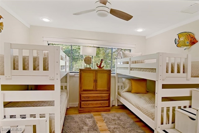 bedroom featuring hardwood / wood-style floors, ceiling fan, and crown molding