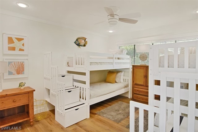 bedroom featuring wood-type flooring, ceiling fan, and ornamental molding