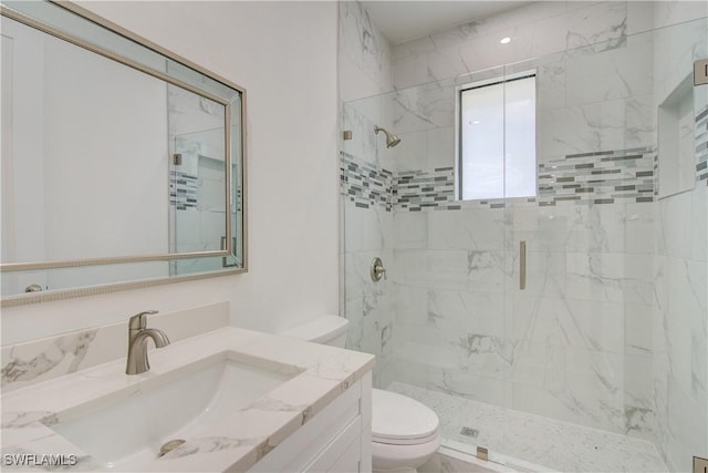 bathroom with vanity, toilet, and a shower with door