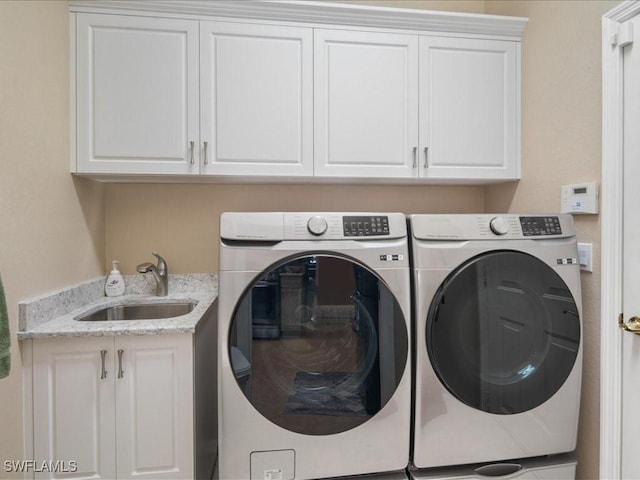 laundry room with washer and clothes dryer, sink, and cabinets