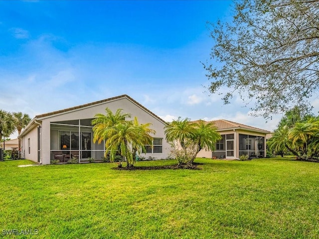 back of house with a sunroom and a yard