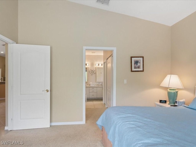 carpeted bedroom featuring connected bathroom and lofted ceiling