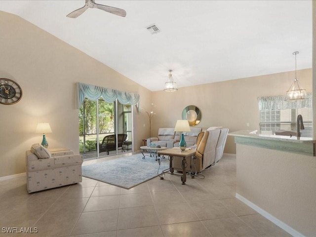 living room with ceiling fan, light tile patterned flooring, and vaulted ceiling