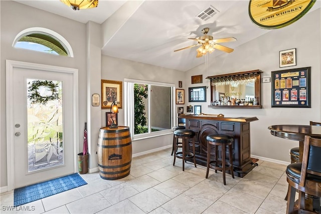 bar featuring ceiling fan, light tile patterned floors, lofted ceiling, and a wealth of natural light