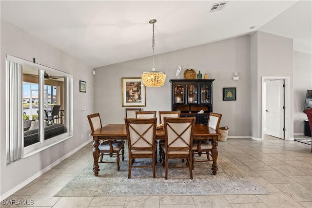 dining space with light tile patterned floors, lofted ceiling, and a notable chandelier