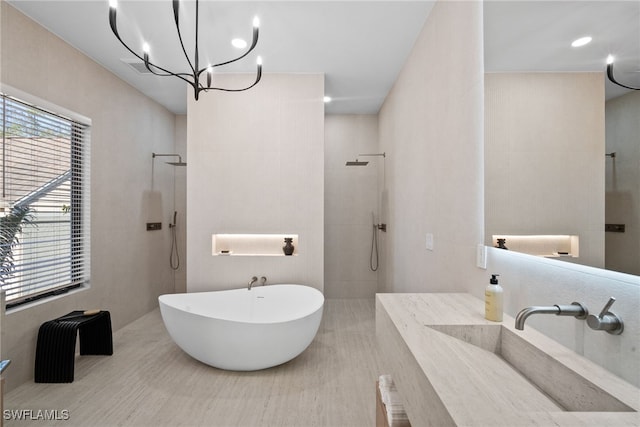 bathroom with a notable chandelier, vanity, and independent shower and bath