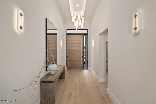 entryway with an inviting chandelier and light hardwood / wood-style flooring