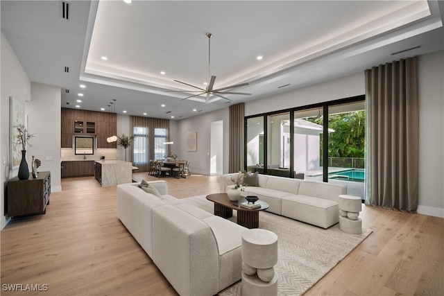 living room with light hardwood / wood-style floors and ceiling fan